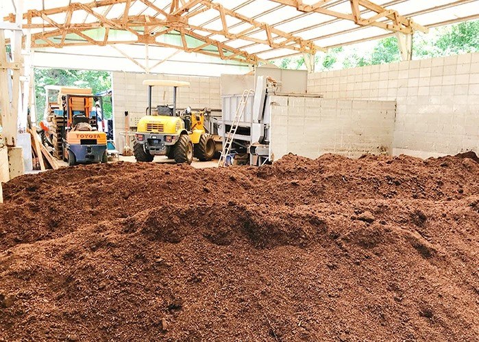 とさやま土づくりセンターの内部。堆肥の山と作業機械。